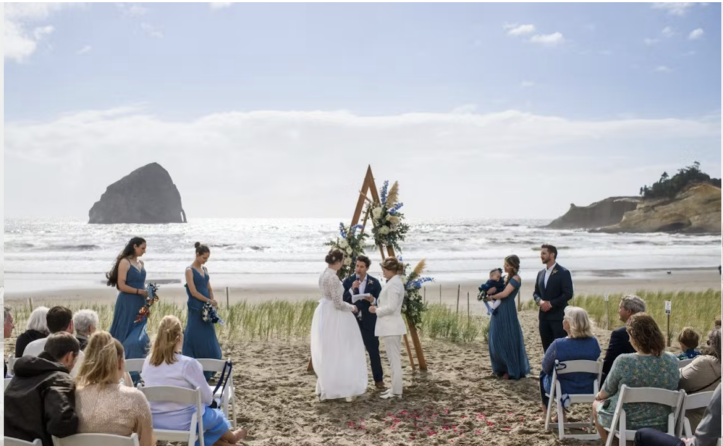 Oceanfront beach wedding ceremony with two brides exchanging vows in front of an Oregon Coast beach.
